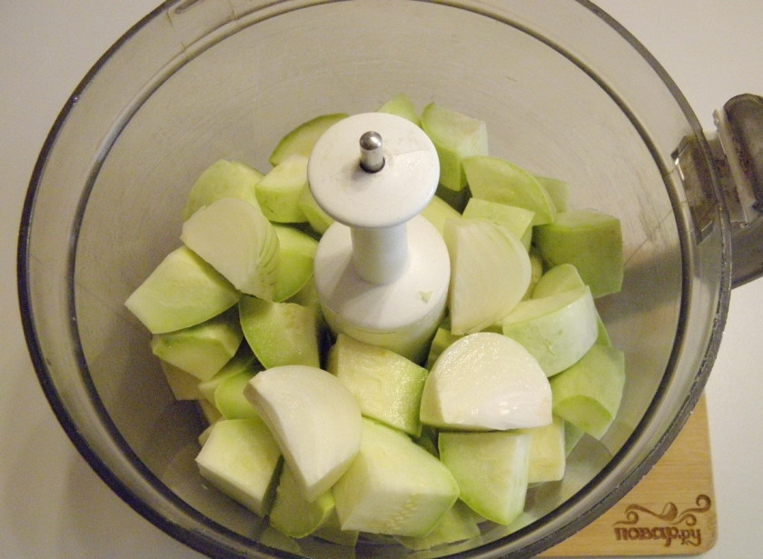 1. Этап. Кабачковая икра с луком на зиму: Я решила воспользоваться комбайном и сложила кабачки в чашу измельчителя. Туда же добавьте очищенный и порезанный на 4 части лук. Измельчите.