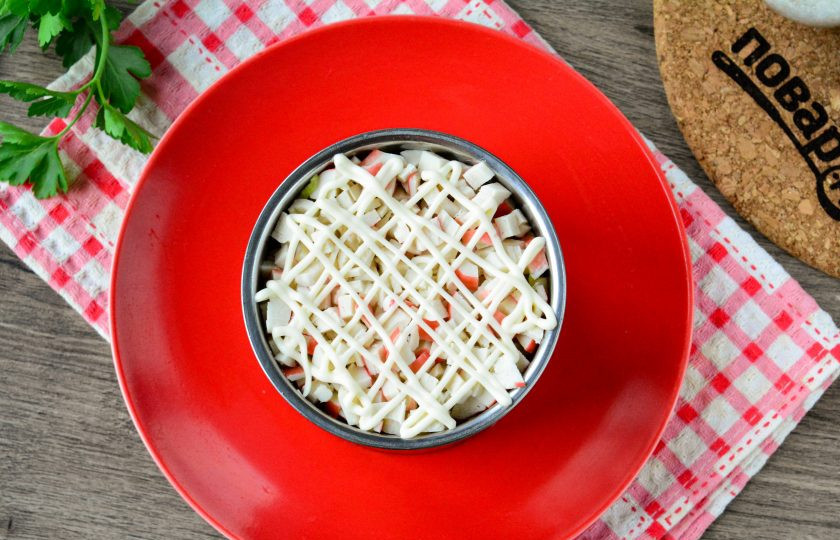 1. Этап. Салат Нежный вкус: Охлажденные крабовые палочки нарежьте кубиками и выложите в салат шестым слоем. Добавьте майонез.