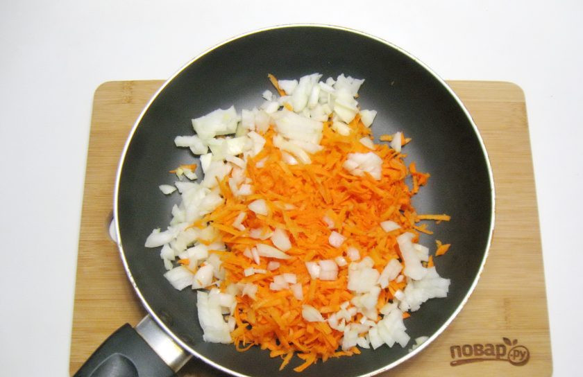 1. Этап. Постные голубцы с овощами: Репчатый лук и морковь очистите, помойте. Лук мелко нарежьте, а морковь натрите на терке. Выложите в сковороду.