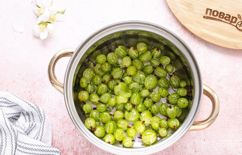 1. Этап. Квас из крыжовника: Переложите крыжовник в кастрюлю. Немного подавите толкушкой ягоды.