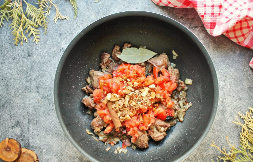 1. Этап. Эсик флейш: Добавьте в казан помидоры в собственном соку, лавровый лист и тертый пряник.