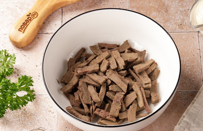 1. Этап. Салат из свиной печени с луком: Отваренную печень немного остудите и нарежьте тонкой соломкой.