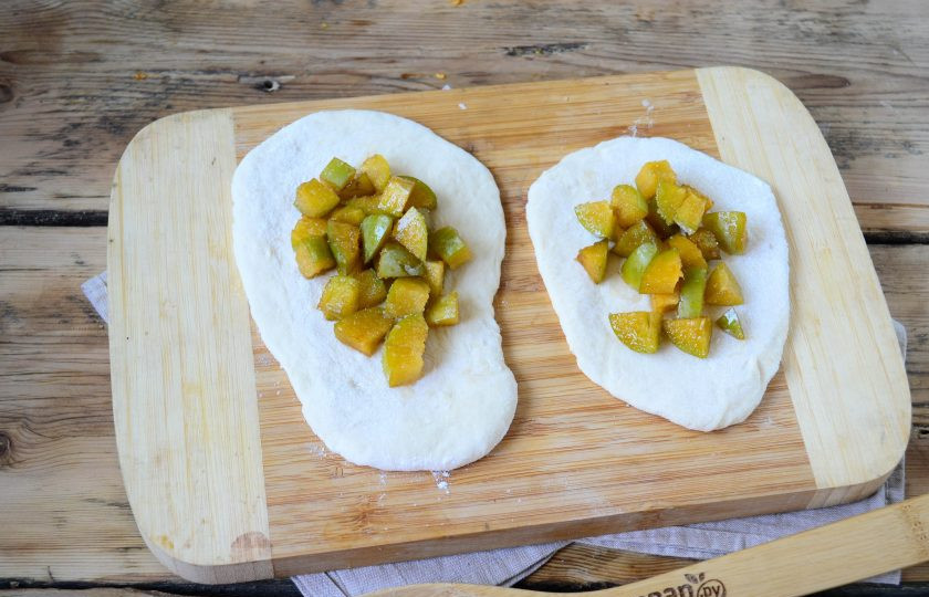 1. Этап. Пирожки со сливой на сковороде: Все тесто разделите на 10 частей. Каждую часть тонко раскатайте в форме овала. На середину положите начинку из слив, сверху присыпьте щепоткой сахара.