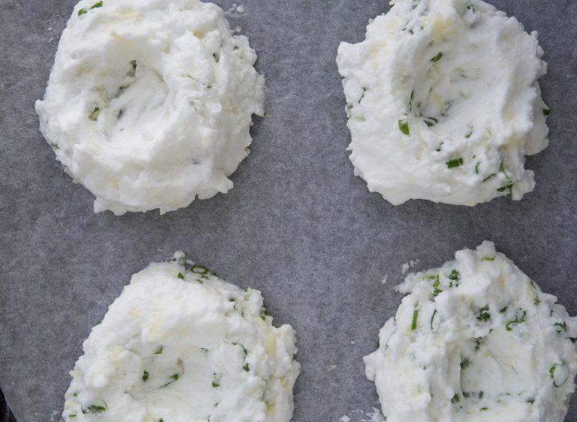 1. Этап. Яичные облака: 3. Потом к луку с сыром аккуратно добавьте белки, перемешав массу. Далее выложите её на противень в 4 порции, сделав углубления в центре.