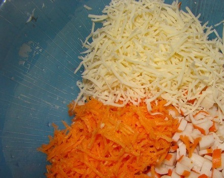 1. Этап. Картофельные котлеты для детей: Если крабовые палочки вы берете замороженные, тогда предварительно достаньте их из морозилки, чтоб они оттаяли. Затем нарежьте их на маленькие кусочки. Морковочку вымойте, поскоблите ножиком и натрите на терке. Твердый сыр также натрите и положите все ингредиенты в миску.
