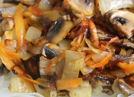 1. Этап. Салат с кальмарами и шампиньонами: 4. В глубокую мисочку отправьте готовую лапшу, а затем обжаренные грибы с овощами.