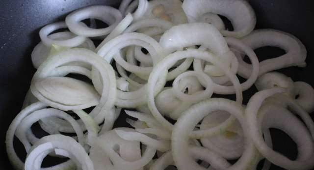 1. Этап. Отбивная по-криольски: 4. В сковороде разогреем растительное масло и обжарим на нем лук, нарезанный колечками.