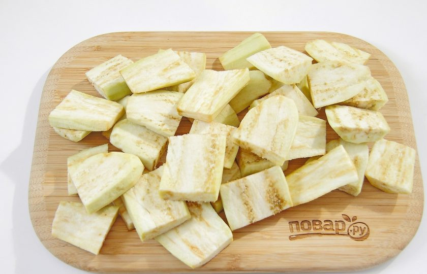 1. Этап. Баклажаны с мясом и овощами: С баклажан снимите шкурку, нарежьте вдоль, а затем квадратиками.