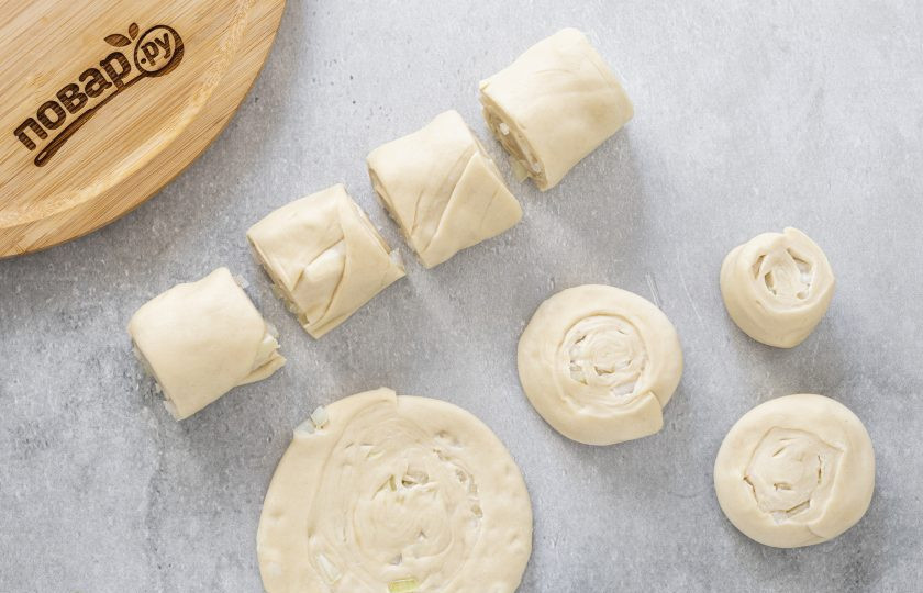 1. Этап. Лепешки на воде с луком: Тесто сверните в рулет. Нарежьте на кусочки длинной около 4 см. Каждый раскатайте в небольшую лепешку толщиной 5-6 мм.