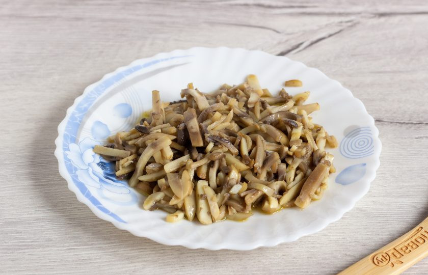 1. Этап. Салат Ласточкино гнездо: Шампиньоны помойте, нарежьте соломкой и обжарьте в течение 2-3 минут на растительном масле.