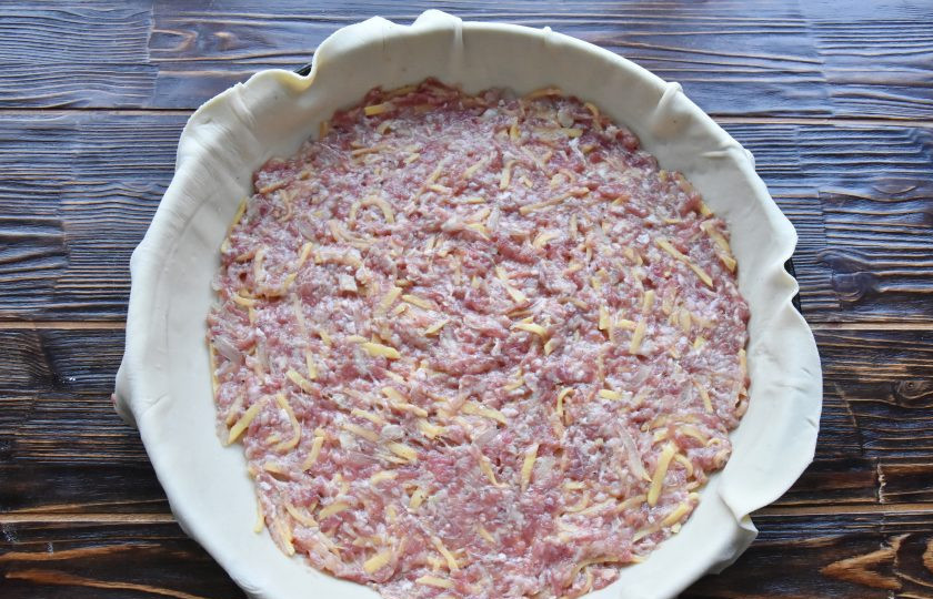 1. Этап. Табасаранское чуду: Начинку разделите на четыре части, выложите часть фарша поверх первого слоя теста и разровняйте тонким слоем по всему периметру.