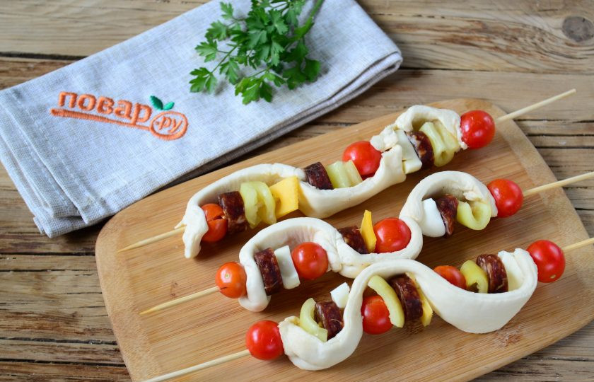 1. Этап. Пицца на шпажках в духовке: Для приготовления пиццы на шпажках вам понадобятся, конечно же, сами бамбуковые шпажки длиной около 20 см. На каждую шпажку наколите тесто, затем попеременно надевайте пепперони, твердый сыр, сладкий перец и помидоры черри, затем огибайте все это тестом и повторяйте процедуру. В общем, надевать начинку вы можете в любом порядке, как вам понравится.