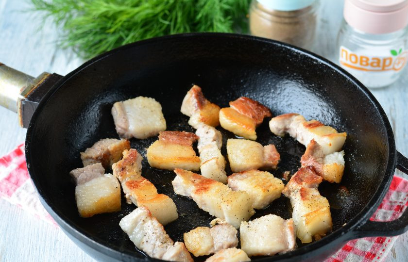 1. Этап. Жареная картошка с грудинкой: Обжарьте кусочки грудинки до золотистого цвета в течение 5-8 минут на среднем огне. Также важно, чтобы вытопился жир, на котором и будем жарить картошку. Другое масло не понадобится. Грудинка должна быть с прослойками сала. Посолите и поперчите грудинку.