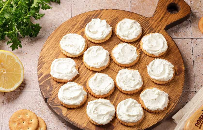 1. Этап. Канапе с креветкой на крекере: Для основы берите солёный крекер. Щедро намажьте печенье сыром. Вообще толщина ингредиентов и их количество — на свой вкус. Возьмите данный рецепт лишь за основу.