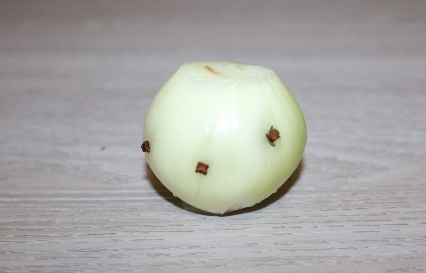 1. Этап. Домашний зельц из свиной рульки: Почистите лук, воткните в него гвоздику.