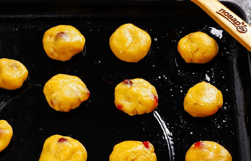 1. Этап. Творожное печенье с клюквой: Разогрейте духовку до 180 градусов. Смажьте противень растительным маслом. Тесто разделите на равные кусочки, скатайте их в колобки и слегка приплюсните. Выложите на противень на равном удалении друг от друга. Поместите противень в духовку на 15-20 минут.