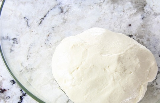 1. Этап. Хачапури по-грузински с сыром: 4. Готовое тесто выложите в мисочку, смазанную маслом. Накройте чистым полотенцем и оставьте в теплом месте на пару часов.