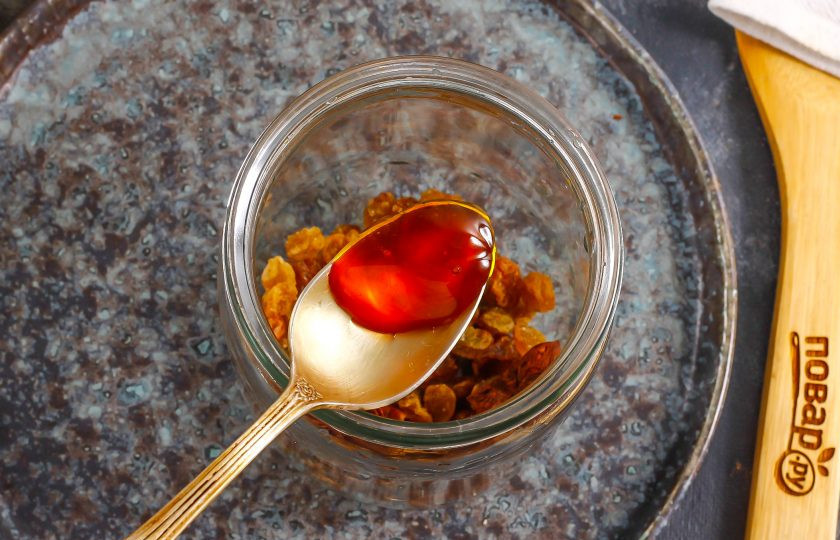 1. Этап. Настойка из изюма на самогоне: Выложите на изюм мед. Не используйте гречишный, он слегка горчит и придаст горечь напитку.