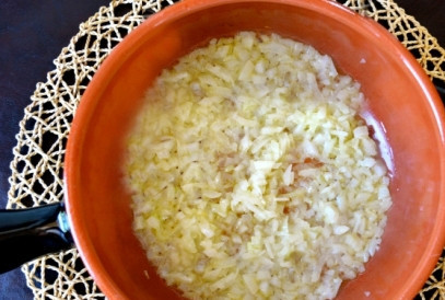 1. Этап. Ризотто с рыбой: Не очень сильно разогреваем сковороду с оливковым и сливочным маслом. Затем добавляем лук и, помешивая, жарим до прозрачности. Добавляем очень мелко нарезанный чеснок.