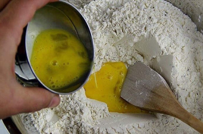 1. Этап. Фокачча (рецепт): 5. Слегка размешайте яйцо и добавьте в миску с мукой.