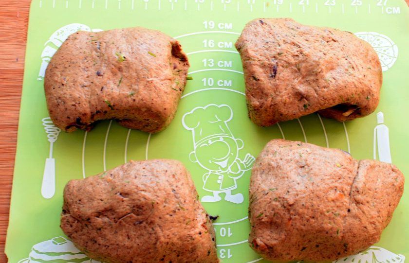 1. Этап. Мини-багеты с жареным луком: Готовое тесто выложите на доску, обомните и разделите на четыре части.