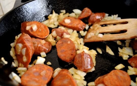 1. Этап. Паэлья с курицей и горошком: 3. Нарежьте ломтиками чоризо и выложите к луку.