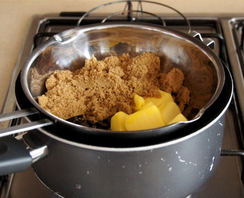 1. Этап. Шоколадные кексы с вишней: Растопите в кастрюле коричневый сахар с шоколадом и сливочным маслом.