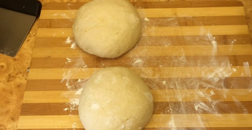 1. Этап. Белый сдобный хлеб: Выложите тесто на рабочую поверхность, присыпанную мукой, и округлите. Разделите тесто на 2 части и округлите. Накройте одну часть теста пленкой, пока будете работать с другой. Раскатайте тесто в цилиндр длинной 40 см.