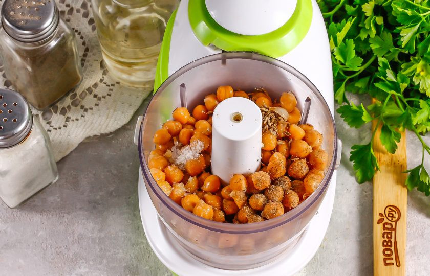 1. Этап. Хумус с петрушкой: Выложите нут в чашу измельчителя или блендера, всыпьте соль, молотый черный перец, молотый сушеный чеснок, зиру.