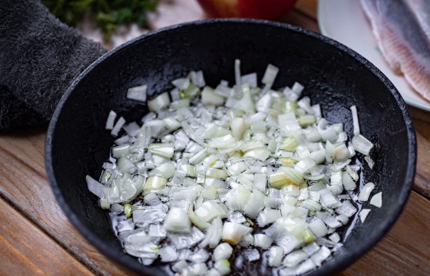1. Этап. Салат Сельдь под одеялом: В чистой сковороде разогрейте растительное масло и выложите измельченный лук, обжаривайте его на небольшом огне до прозрачности, затем выложите в отдельную тарелку охлаждаться.