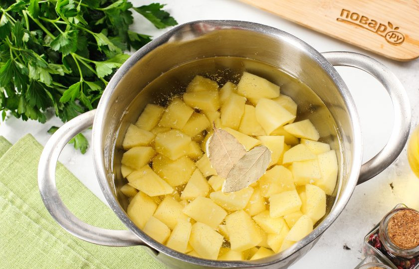 1. Этап. Суп с килькой в томате с вермишелью: Картофель нарежьте небольшими кубиками или брусочками, как вам больше нравится. В кастрюлю с водой или бульоном отправьте нарезанный картофель и лавровый лист. Доведите всё до кипения, далее пламя убавьте и варите картошку под крышкой до готовности.