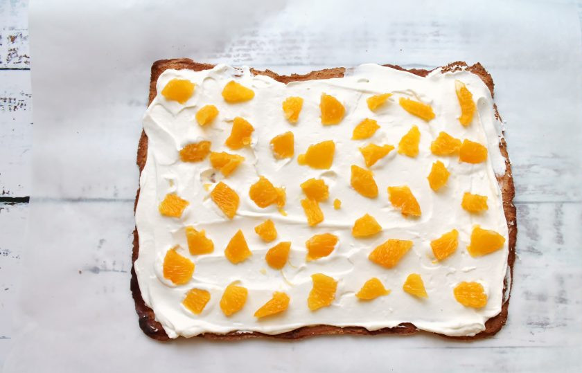 1. Этап. Меренговый рулет с мандаринами: Мандарины очистите от кожуры, разделите на дольки, удалите все перегородки и пленки. Разрежьте их на кусочки и разложите поверх крема.