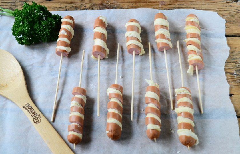 1. Этап. Сосиски в тесте на палочке Твистер: Тесто порежьте на длинные полоски шириной 5 мм. Вложите полоски теста в разрезы, чтобы получилась спираль, как на фото.