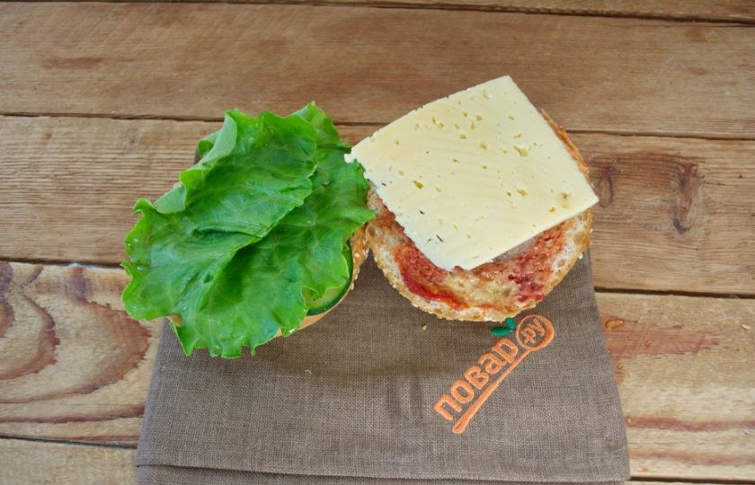 1. Этап. Бургер Овощные прятки: На горячую котлетку выложите кусочек сыра. Я использую твердый сыр, но если у вас тостовый сыр, он расплавится сам по себе от жара котлеты. Если вы используете твердый сыр, поместите половинку булочки с котлетой и сыром на 30 секунд в микроволновку. Сыр расплавится, но с булочки не убежит.