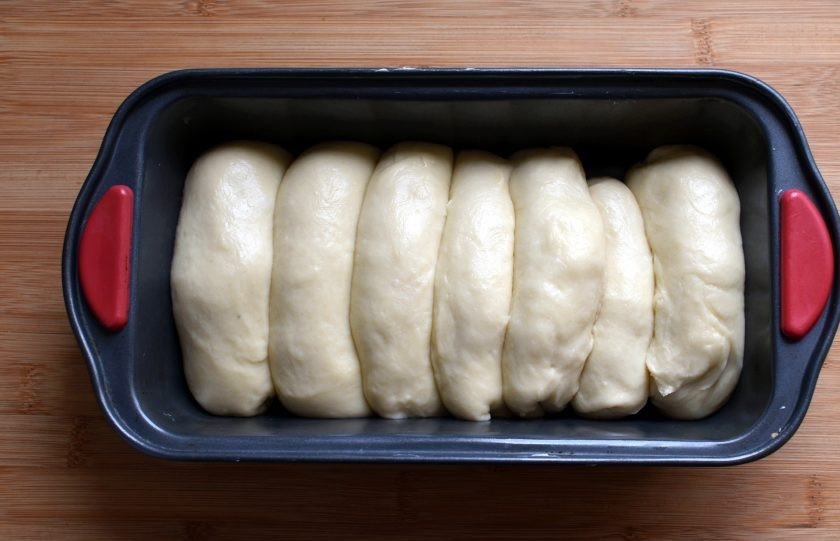 1. Этап. Сайки с заварным кремом: Уложите сайки швом вниз близко друг к другу в прямоугольную форму. Удобно брать форму для кекса. Дайте сайкам подойти и смажьте сверху взбитым яйцом.