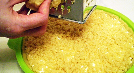 1. Этап. Песочный пирог с творожной начинкой: Натираем сверху замороженное предварительно тесто и равномерно его распределяем.