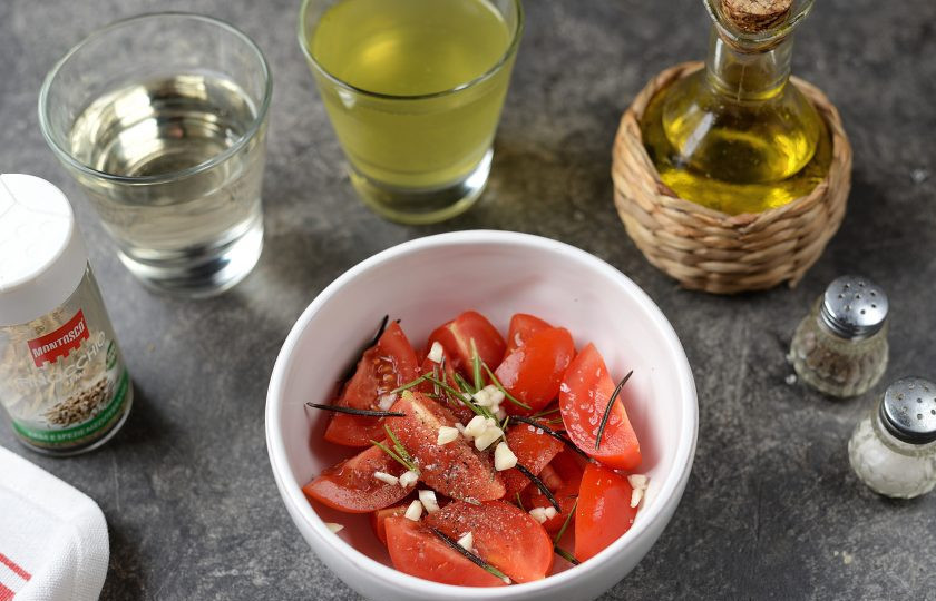 1. Этап. Говядина по-сицилийски: Помидоры порежьте четвертинками, добавьте 2 столовые ложки оливкового масла, чуть посолите морской солью, поперчите, всыпьте свежий розмарин и нарезанный зубчик чеснока, перемешайте.