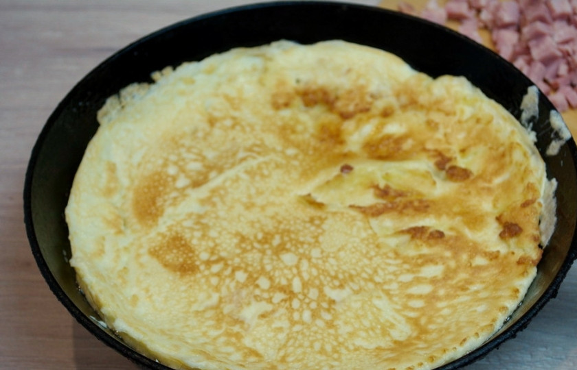 1. Этап. Рис по-кантонски: Разогрейте сковороду. Влейте на неё немного растительного масла. Вылейте омлетную массу в сковороду и обжарьте омлет.