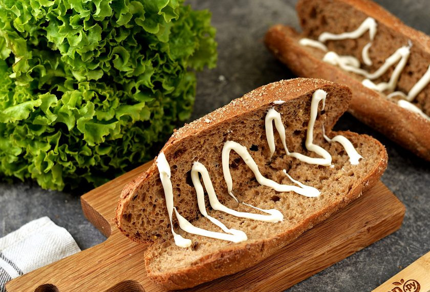 1. Этап. Бутерброд с солеными огурцами: Надрежьте булочки с одной стороны, разверните их книжкой, щедро смажьте майонезом.