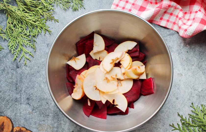 1. Этап. Свекольный уксус: Яблоко разрежьте пополам и тонко нарежьте вместе с сердцевиной. Выложите яблоки в миску со свеклой.