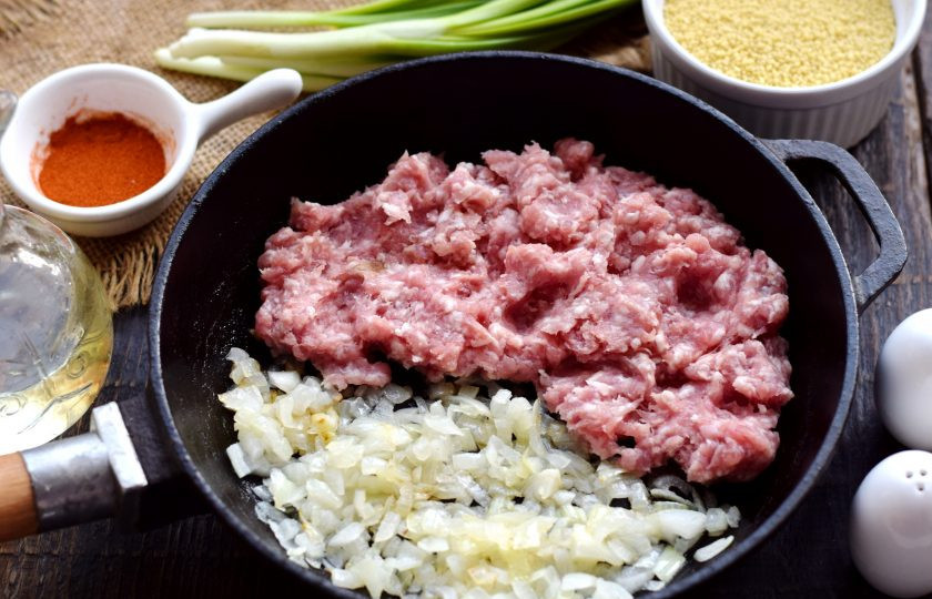 1. Этап. Кус-кус с фаршем: Пассерованный лук отодвиньте на один край сковороды, на пустую поверхность влейте еще немного масла, выложите мясной фарш.