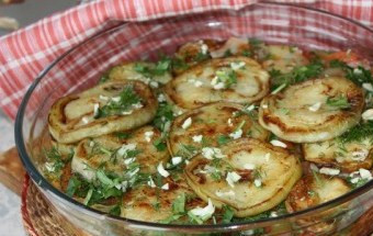 1. Этап. Баклажаны по-кубански: 6. Теперь самый важный этап - сервировка блюда. Первым слоем кладем баклажан, сверху притрушиваем чесноком, затем помидоры с луком и в завершении - зелень.