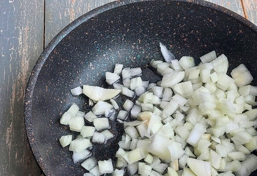 1. Этап. Сливочная гречка с курицей в духовке: Лук почистить, помыть, нарезать кубиками. Переложить в сковороду, смазанную растительным маслом.