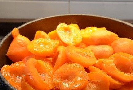 1. Этап. Абрикосовое варенье быстро: Промываем абрикосы под холодной водой и вытираем их бумажным полотенцем. Разрезаем каждый плод пополам и удаляем косточку, выкладываем абрикосы в широкую кастрюлю с толстым дном.