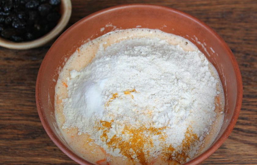 1. Этап. Морковные кексы с изюмом: Добавляем муку, куркуму и гашеную уксусом соду. Все перемешиваем.