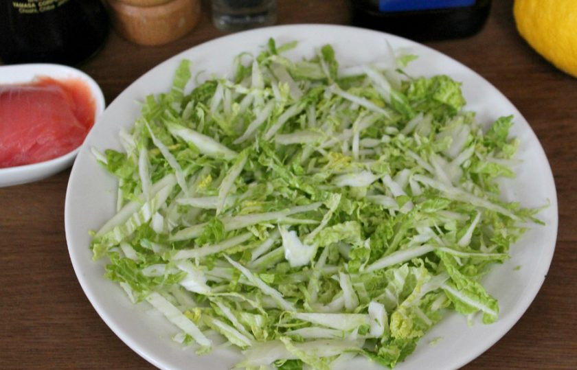 1. Этап. Салат с красной рыбой и пекинской капустой: Капусту нарезаем тонко и высыпаем на плоскую тарелку.