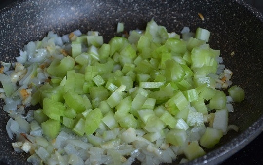 1. Этап. Гарнир из перловки с овощами: 3. Пока лук обжаривается до прозрачности, нарежьте мелко стебель сельдерея, выложите его тоже в сковороду.