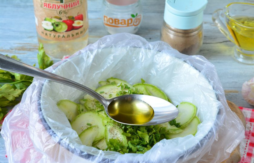 1. Этап. Быстрая засолка кабачков в пакете: Влейте масло и яблочный уксус.