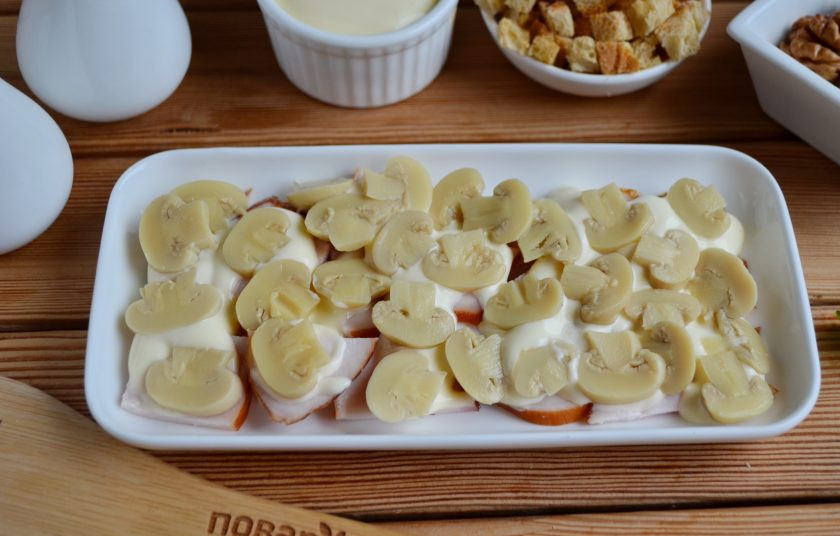 1. Этап. Салат с грибами и сыром Искушение: Маринованные шампиньоны порежьте пластинками. Распределите равномерно по курочке.