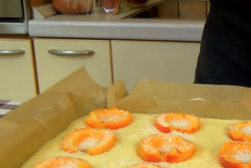 1. Этап. Простой пирог с абрикосами: 3. Сверху на тесто выложите половинки абрикосов срезом вверх и посыпьте сахаром. Отправьте пирог в разогретую до 190 градусов духовку на 40 минут.